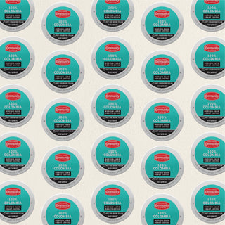 Rows of K-Cup lids for Community Coffee One-Hundred Percent Colombia medium-dark roast lie flat against a white background.