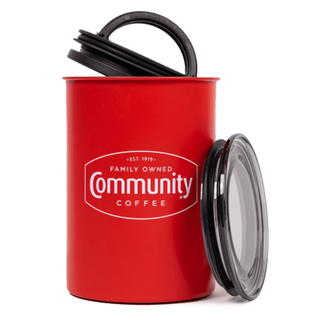 An Airscape coffee canister bearing the Community Coffee logo in white text, with the lid removed and leaned against the canister.
