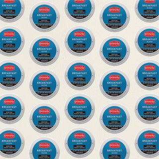 Rows of K-Cup lids for Community Coffee Breakfast Blend medium roast lie flat against a white background.