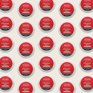 Rows of K-Cup lids for Community Coffee Christmas Blend medium roast lie flat against a white background.