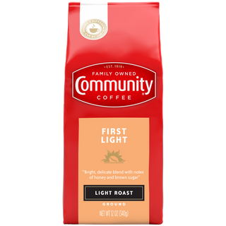 A twelve-ounce bag of ground Community Coffee First Light, light roast, shown from the front.