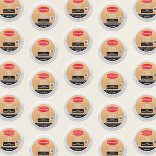 Rows of K-Cup lids for Community Coffee First Light, light roast, lie flat against a white background.