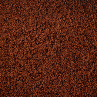 A flat layer of ground coffee, ground to a medium size and light brown in color, shown from the top down.