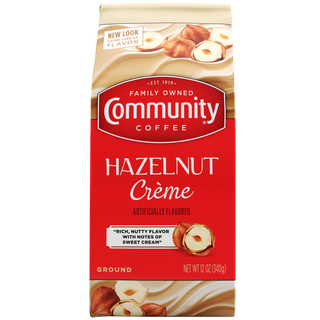 A twelve-ounce bag of ground Community Coffee Hazelnut Crème flavored coffee, shown from the front.