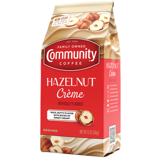 A twelve-ounce bag of ground Community Coffee Hazelnut Crème flavored coffee, rotated a quarter-turn to the left.