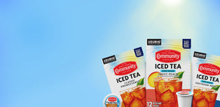 Three boxes of Community Iced Tea K-Cups, including Classic Unsweetened, Sweet Peach and Southern Sweet varieties, on a light-blue background with rays of sunshine.