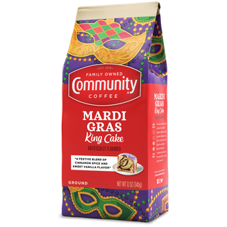 A twelve-ounce bag of ground Community Coffee Mardi Gras King Cake flavored coffee, rotated a quarter-turn to the left.