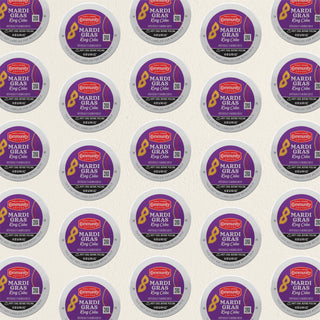 Rows of K-Cup lids for Community Coffee Mardi Gras King Cake flavored coffee lie flat against a white background.
