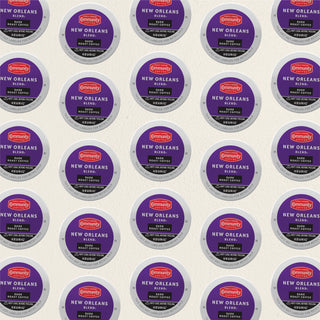 Rows of K-Cup lids for Community Coffee New Orleans Blend dark roast lie flat against a white background.