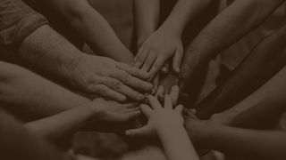 A circled group of people put their hands in the center, shown in sepia tone.
