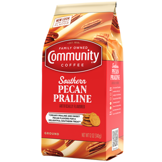 A twelve-ounce bag of ground Community Coffee Southern Pecan Praline flavored coffee, rotated a quarter-turn to the left.