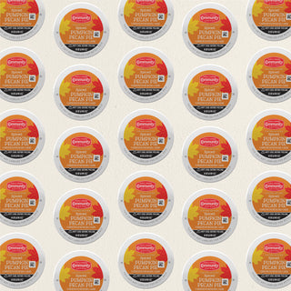 Rows of K-Cup lids for Community Coffee Spiced Pumpkin Pecan Pie flavored coffee lie flat against a white background.