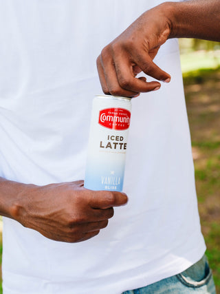A person opening a Community Coffee Vanilla Bliss Iced Latte can.