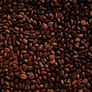 A flat layer of roasted whole coffee beans, a variety of rich browns in color, shown from the top down.
