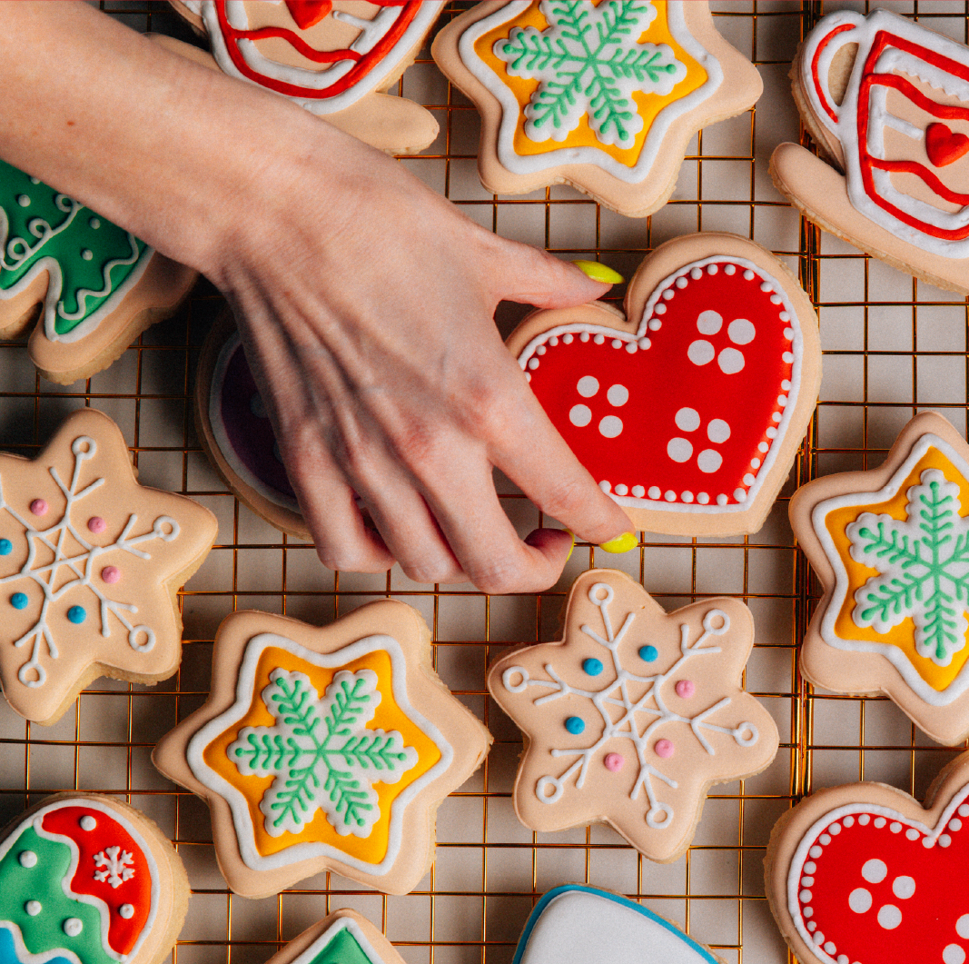 Hand reaching across a tray of cookies